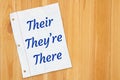 Their TheyÃ¢â¬â¢re There grammar message on lined crumpled paper on weathered wood